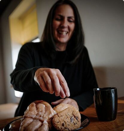 A smiling employee, in a relaxed work environment, serves herself dessert. The image reflects the work-life balance encouraged at Erod, where telecommuting, flexible working hours and team-building activities are valued.