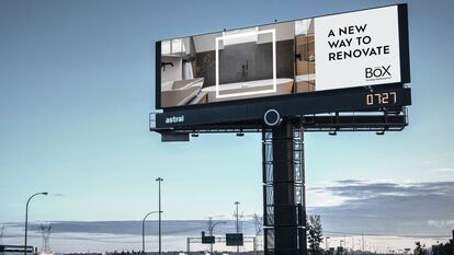 A highway billboard displays an advertisement for BOX, a bathroom renovation company. The billboard shows a modern bathroom with a bathtub and shower, and the text 