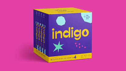 A yellow and blue box containing 4 cylinders of Indigo brand CO2 on a pink background. The Indigo logo and the slogan “Vos bulles d'ici” (“Your bubbles from here”) are visible on the box.